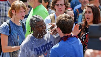 A counter demonstrator is splashed with water after he was hit by pepper spray by a white nationalist demonstrator at the entrance to Lee Park in Charlottesville. Steve Helber / AP
