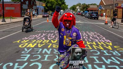 A protester kneels during a call for justice for George Floyd during his brother Terrence's visit, outside the Cup Foods on June 1, 2020 in Minneapolis, Minnesota. AFP