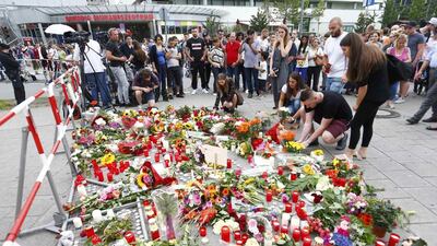 People place flowers in front of the Olympia shopping centre in Munich, where Ali David Sonboly carried out his attack a day before. Arnd Wiegmann/Reuters