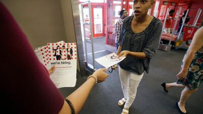 In this Friday, Oct. 13, 2017, photo, a potential job candidate takes a flyer from a human resources representative at a Target store in Dallas. The U.S. government issues the October jobs report, Friday, Nov. 3, 2017. (AP Photo/LM Otero)