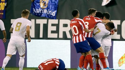 Atletico Madrid's Thomas Lemar reacts after being injured as teammates fight with Real Madrid players. AP Photo