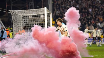 Liverpool's Kostas Tsimikas clears a flare off the pitch after Jota's goal.PA