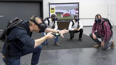Martin Rademacher (L), who is in charge of the VR holodeck project at Audi, checks out a prototype with other technicians. Courtesy Audi
