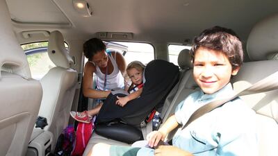Anthea Modin from South Africa buckles up her daughter, Thalia, 2, and her son, Trond, 8. Pawan Singh / The National
