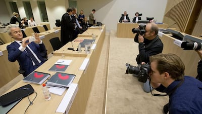 Firebrand Dutch lawmaker Geert Wilders, left, takes pictures of photographers as he appeared in court for a pretrial hearing at a high-security court on charges of inciting hatred, in Amsterdam, Netherlands. AP