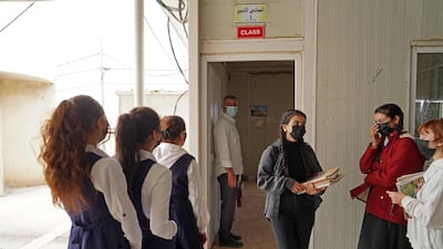 Girls receive text books before heading to class on the first day of school at a Yazidi displacement camp in the Sharya area near the city of Dohuk in Iraqi Kurdistan. AFP