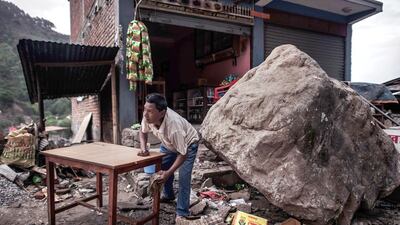 A man cleans a table next to a rock that fell outside his shop in Melamchi, an area of rice-farming communities in central Sindhupalchok district, during a 7.8-magnitude earthquake in Nepal on April 26, 2015. Philippe Lopez / AFP / May 1, 2015