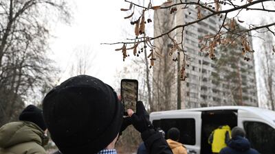 A visitor takes a smartphone picture of abandoned buildings in the ghost town of Pripyat, not far from Chernobyl nuclear power plant. AFP