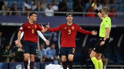 Referee Espen Eskas shows a yellow card to Spain's Antonio Blanco, left. AP