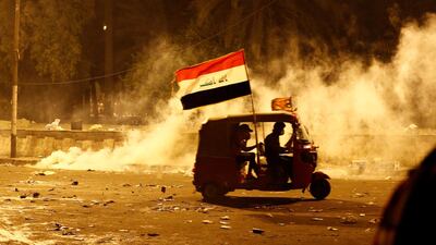 A tuk-tuk drives away from tear gas fired by Iraqi security forces during anti-government protests in Baghdad on October 26, 2019. Reuters
