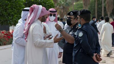 Demonstrators speak with police officers as they gather in front of Kuwait National Assembly building. Reuters