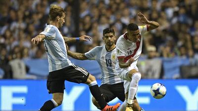 Peru's Sergio Pena (R) is marked by Argentina's Lucas Biglia (L) and Ever Banega during their 2018 World Cup qualifier football match in Buenos Aires on October 5, 2017. / AFP PHOTO / Juan MABROMATA