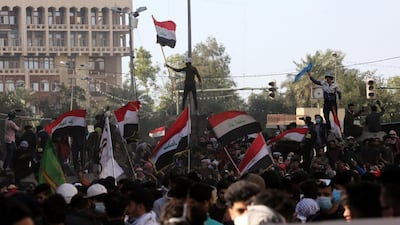 Iraqi protesters carry the Iraqi national flag as they gather on concreat blocks which were used by security forces to close the Al-Khilani square in central Baghdad, Iraq. EPA