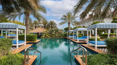 The pool at Al Habtoor Polo Resort is surrounded by greenery, sun loungers and daybeds. Photo: Al Habtoor Polo Resort