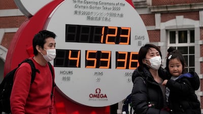 A family takes a photograph in front of a countdown clock in Tokyo. EPA