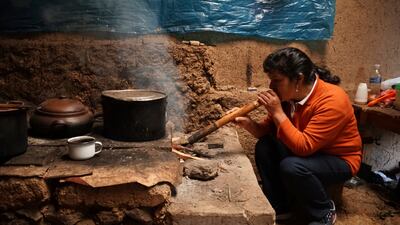 Lilia Paredes, the first lady of Peru, uses a wood-burning stove in the hamlet of Chugur. AP