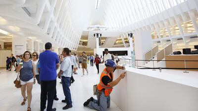 A worker puts finishing touches in the World Trade Center Transportation Hub, in New York. The Westfield World Trade Center, a retail mall, openend this week. Mark Lennihan / AP