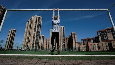 A boy hangs from a goalpost in St Petersburg, Russia. Anton Vaganov / Reuters