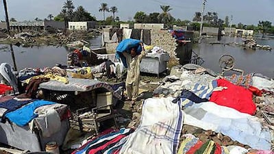 People search for their belongings amid remains of a house destroyed by the floods as they return to their village in Kasba Gujrat, near Muzaffargarh, in Punjab province.