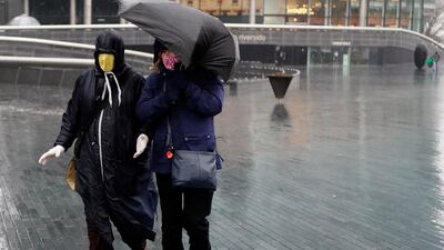 Pedestrians brave the rainy and windy weather in London. AP Photo