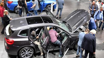 Visitors check every nook and cranny at the Frankurt Motor Show. Martin Meissner / AP Photo