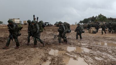 Israeli soldiers walk in the rain near the Gaza border. EPA