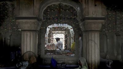 A priest reads the Sikh holy book, the Guru Granth Sahib, while pilgrims gather at a shrine in Lahore, Pakistan. Arif Ali / AFP