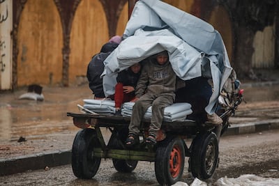 Two boys shelter from the rain on a donkey cart in Deir Al Balah. AFP