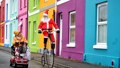 Father Christmas Mel Glass, a cycling instructor, passes Sandy Hale on his penny farthing, bringing Christmas cheer to Gloucester, west England. Taken by Paul Nicholls. PA