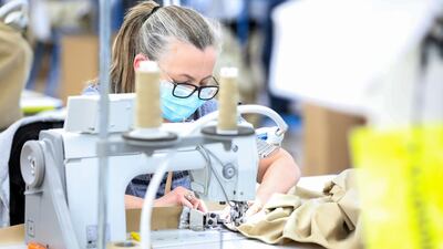 A machinist sews a protective gown at the Burberry's factory.