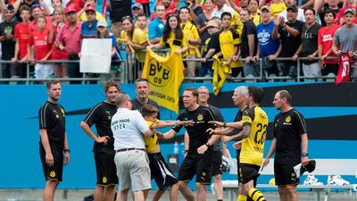Borussia Dortmund's Christian Pulisic rushes out on the pitch as a fan is detained. AFP