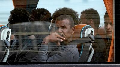 A group of people thought to be migrants are driven away from Dover. PA