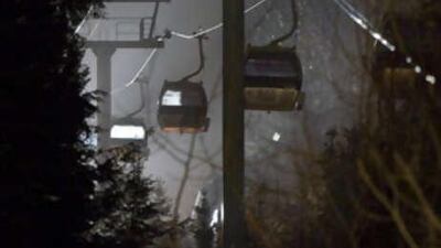 Rescue workers shine lights into gondolas looking for trapped people after a support tower partially collapsed.