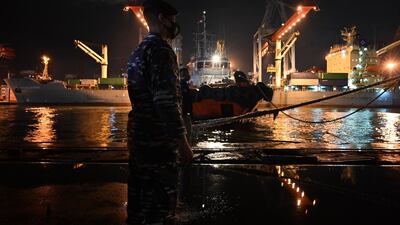 A Navy sailor stands guard as the KRI Gilimanuk (531) warship prepare to leave for a search and rescue operation for the Sriwijaya Air flight SJY182 from the Tanjung Priok port in Jakarta. AFP