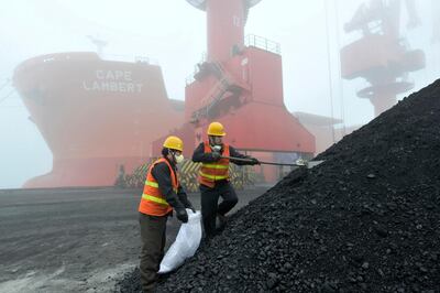 Workers take samples of imported Australian coal at a port in Rizhao in eastern China's Shandong province. AP