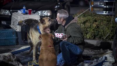 A Camp Fire evacuee plays with an abandoned dog in Chico, California. Bloomberg