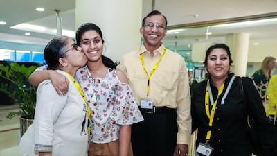 Shruti Krishnamoorthy, 16, gets a kiss from her grandmother, Vishwanathan, together with father, Krishnamoorthy and mother, Hema at the GEMS Wellington International School in Dubai. Victor Besa/The National