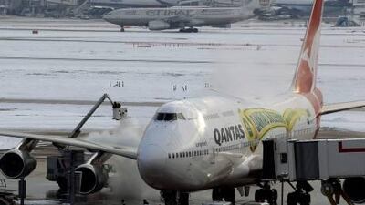 Workers defrost a plane at Heathrow Airport in London yesterday.