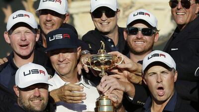 United States captain Davis Love III is surrounded by his players as they pose for a picture during the closing ceremony of the Ryder Cup. David J. Phillip / AP
