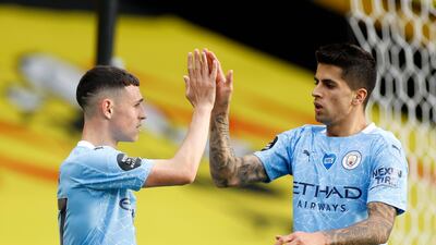 Manchester City's Phil Foden, left, celebrates with Manchester City's Joao Cancelo after scoring his side's third goal. AP