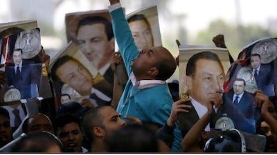 Pro-Mubarak demonstrators chant slogans in front of the National Television building in Cairo Monday.