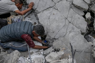 Palestinians search for bodies and survivors in the rubble of a destroyed house following an Israeli air strike on Al Nusairat refugee camp, southern Gaza. EPA