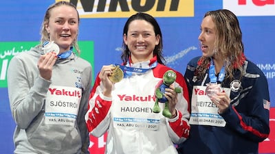 Gold medalist Siobhan Haughey, centre, alongside Sarah Sjostrom, left, who took silver and bronze winner Abbey Weitzeil after the women's 100m freestyle final at the Fina World Swimming Championships in Abu Dhabi. EPA