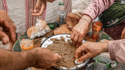 Residents share a meal of lentils in their tent. AFP