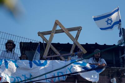 Israelis stand on the roof of a Palestinian house controlled by settlers, during protests in Sheikh Jarrah in East Jerusalem. EPA