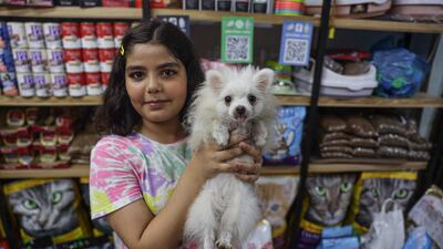 Palestinian Mais Miqdad with the dog she is buying from a pet shop in Gaza city. Majd Mahmoud / The National