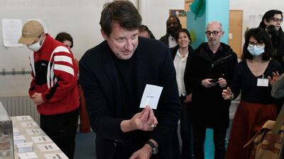 The French ecologist party EELV's presidential candidate, Yannick Jadot, takes ballots before voting at a polling station in Paris. AFP