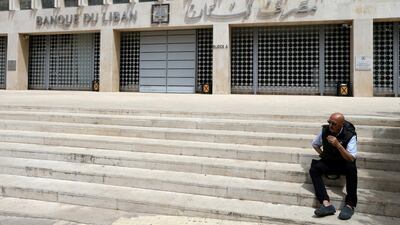 A man sits on steps in front of the Central Bank in Beirut. Lebanon needs structural reforms for economic recovery. Reuters