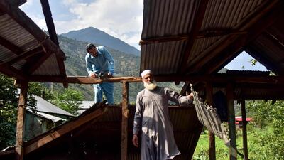 Kashmiri men look at a damaged part of their house following recently cross border shelling at the Line of Control, the de facto border between Pakistan and India, in Neelum Valley of Pakistan-administered Kashmir. AFP