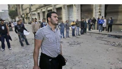 Anti-government protesters guard an entrance to Tahrir Square to prevent pro-Mubarak supporters from enetering.